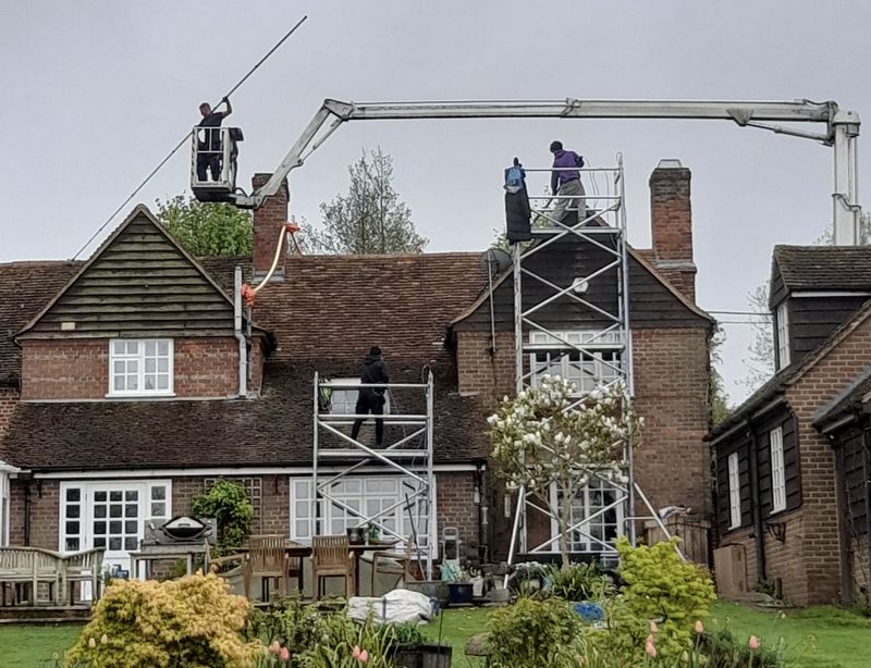 The Moss Cleaners using cherry picker and scaffolding to clean roof safely and professionally in Crawley Down, West Sussex